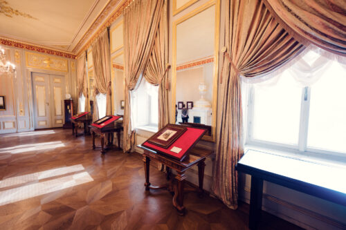 Luxurious room with antique furnishings and draped curtains in Albertina Museum.
