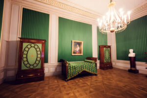 Green-walled bedroom with antique furniture and decor in Albertina Museum.