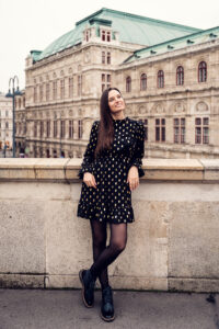 Posing in front of Albertina Museum in Vienna with classic architecture.