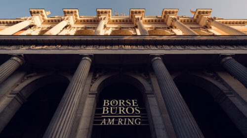 The Vienna Stock Exchange building features a grand entrance framed by towering columns and intricate architectural details, symbolizing its historical importance and stately presence along the Ringstrasse.