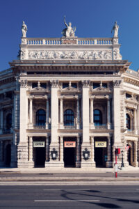 Burgtheater's grand columns and statues, showcasing Vienna's rich artistic heritage.