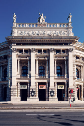 Burgtheater's grand columns and statues, showcasing Vienna's rich artistic heritage.