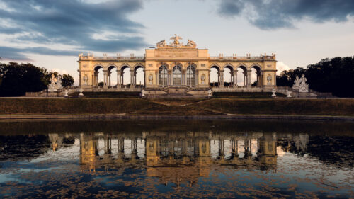 Gloriette's perfect reflection mirrored in still waters, creating a symmetrical masterpiece of baroque architecture.