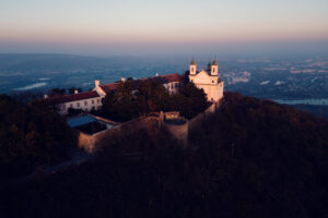 Historic bell tower on Leopoldsberg against dramatic sky backdrop.