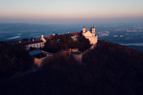 Historic bell tower on Leopoldsberg against dramatic sky backdrop.