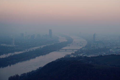 Majestic Danube River curves viewed from Leopoldsberg summit, where the historic river creates dramatic bends through Vienna's landscape.