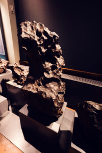 Iron meteorite specimen at Natural History Museum Vienna (Naturhistorisches Museum Wien), featuring metallic space rock with distinctive surface patterns in astronomy section on Maria-Theresien-Platz.
