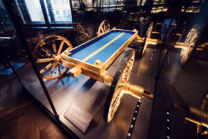 Ornate ceremonial carriage display at Natural History Museum Vienna (Naturhistorisches Museum Wien), featuring elaborate imperial state coach with decorative details in historical collection on Maria-Theresien-Platz.