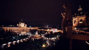 Natural History Museum Vienna during Christmas market (Naturhistorisches Museum Wien), featuring Renaissance Revival architecture with festive wooden stalls on Maria-Theresien-Platz.