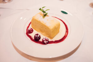 Classic Topfenkuchen (quark cake) at Plachutta served with velvety vanilla sauce.