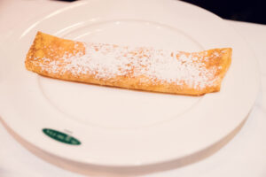 Traditional Viennese "Palatschinken" at Plachutta Stammhaus Hietzing featuring delicate crepes filled with homemade apricot jam and dusted with powdered sugar.