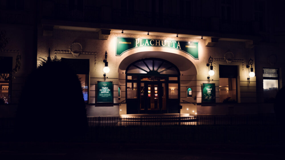 Evening facade of Plachutta Stammhaus Hietzing featuring illuminated entrance and classic restaurant signage.