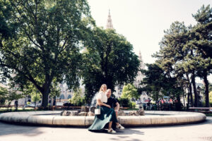 Adriana and Mario posing by the ornate fountain in Rathauspark (Rathauspark Brunnen).