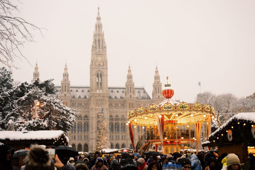 Rathaus Vienna during Christmas market season with festive decorations and lighting.