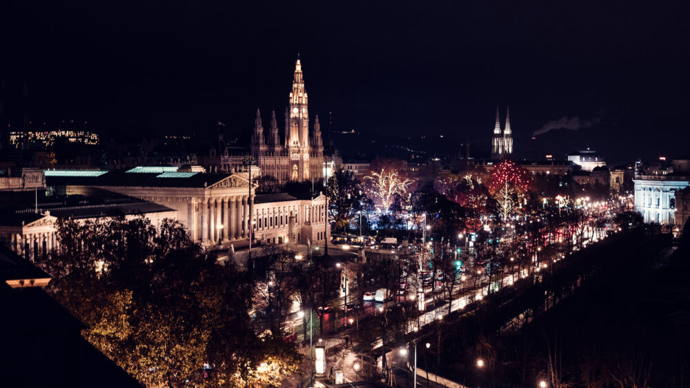 Vienna City Hall (Rathaus) illuminated at night with its spires lit against the dark sky along the Ringstrasse.