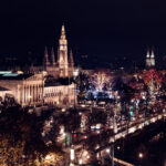 Vienna City Hall (Rathaus) illuminated at night with its spires lit against the dark sky along the Ringstrasse.