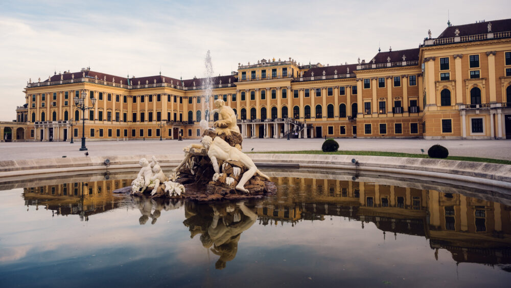 Enchanting fountain scene at Schönbrunn Palace entrance.