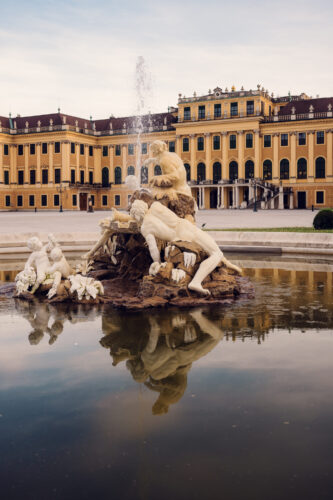 Enchanting fountain scene at Schönbrunn Palace entrance.