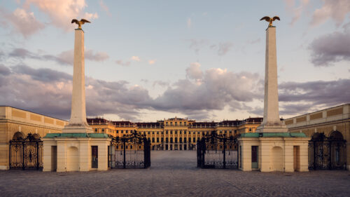 Historic entrance gate to Schönbrunn Palace, baroque Austrian imperial palace main entry with elaborate wrought iron gates and classical stone architecture.