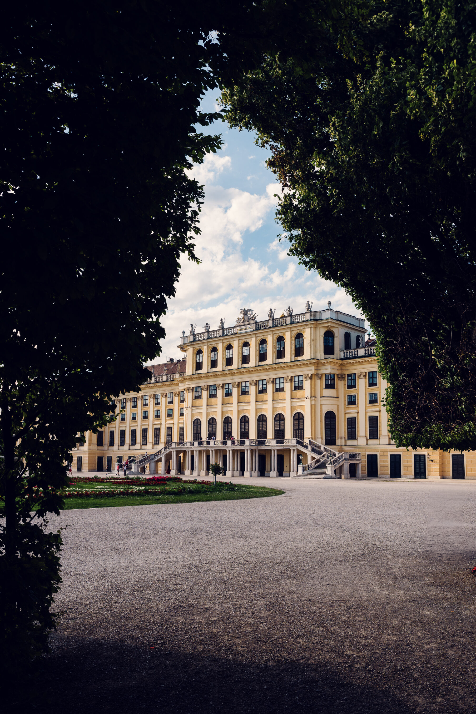 Schönbrunn Palace baroque facade with colorful flower gardens in foreground.