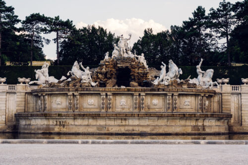 Neptune Fountain at Schönbrunn Palace gardens with baroque sculpture and water features.
