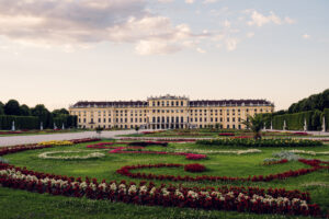 Schönbrunn Palace baroque facade with colorful flower gardens in foreground.