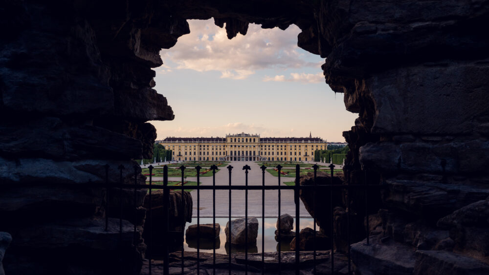 Neptun baroque fountain with mythological figures and palace view behind.