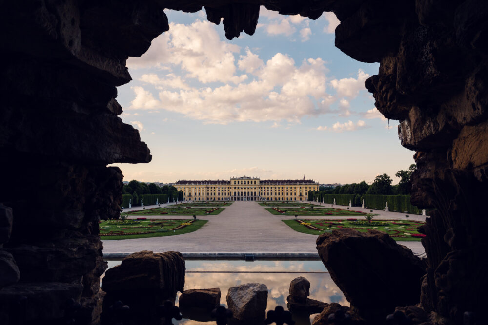 Neptun baroque fountain with mythological figures and palace view behind.