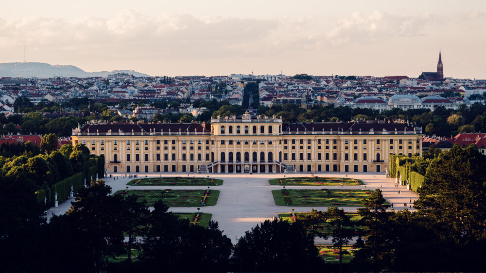 Panoramic daytime view from the Gloriette's terrace, capturing Schönbrunn Palace and Vienna's sprawling landscape in crystal-clear light.