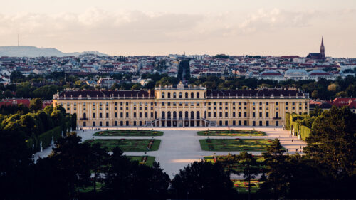 Panoramic daytime view from the Gloriette's terrace, capturing Schönbrunn Palace and Vienna's sprawling landscape in crystal-clear light.