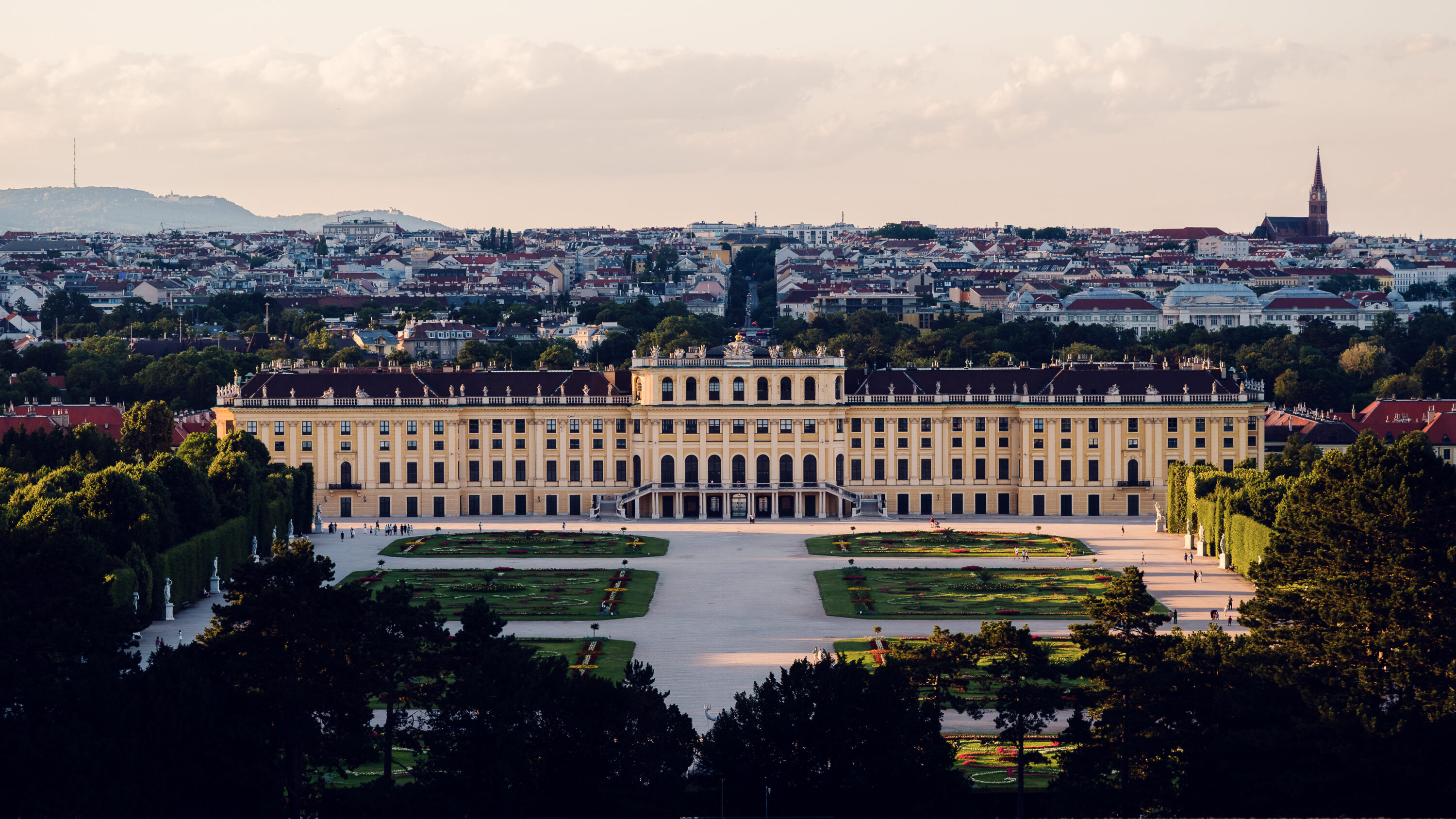 Panoramic daytime view from the Gloriette's terrace, capturing Schönbrunn Palace and Vienna's sprawling landscape in crystal-clear light.
