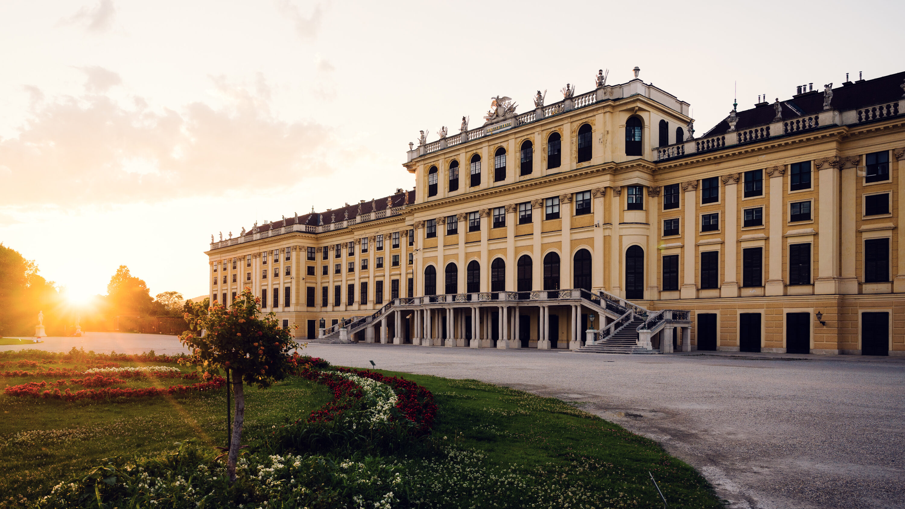 Schönbrunn Palace Schloss Schönbrunn baroque facade illuminated by golden sunset light.
