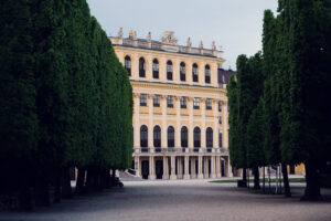 Schönbrunn formal gardens aerial view showing geometric design and palace backdrop.