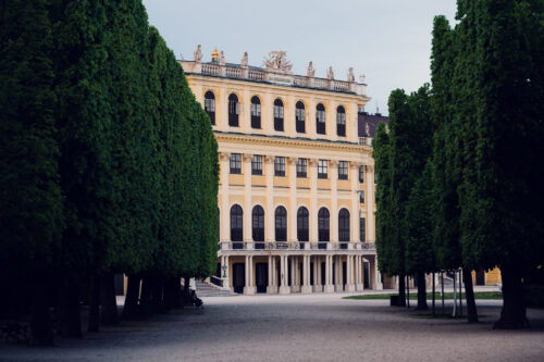 Schönbrunn formal gardens aerial view showing geometric design and palace backdrop.