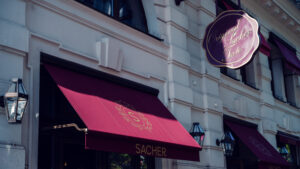Entrance of Café Sacher Bel Étage, featuring the iconic sign for the Original Sacher Torte.