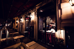 Glimpse into Café Sacher Bel Étage from outside, with raindrops painting the window.