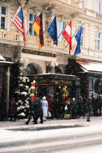 Snow-covered entrance to Hotel Sacher, welcoming guests to a world of Viennese elegance.