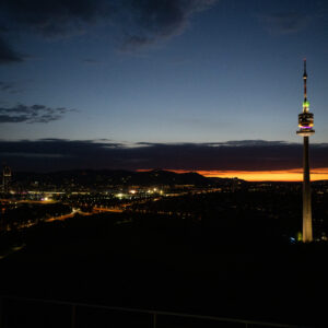 Donauturm Vienna sunset 252 meter tower against orange sky.