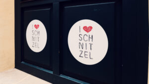 Entrance door of Figlmüller Bäckerstrasse featuring the playful 'I Love Schnitzel' sticker.