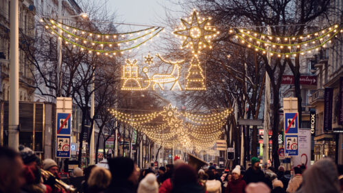 Mariahilfer Strasse Vienna Christmas evening with illuminated holiday decorations festive street lights and seasonal shopping crowds.