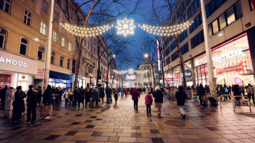 Vienna Mariahilfer Strasse Christmas illuminations featuring holiday string lights festive storefront decorations and seasonal shopping district ambiance.