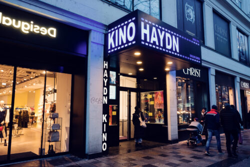 Haydn Kino cinema entrance Mariahilfer Strasse Vienna at night with illuminated movie theater signage.