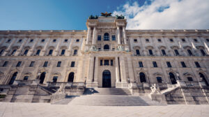 Grand facade of the Hofburg Palace viewed from Burggarten, showcasing Vienna's imperial grandeur.