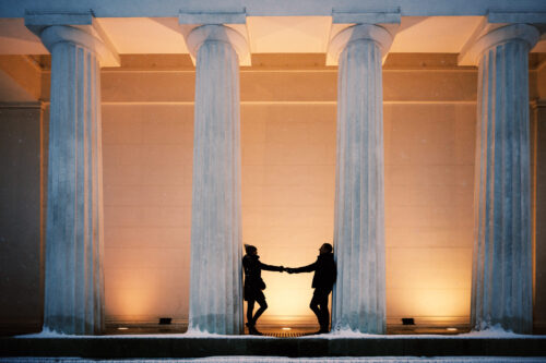 Adriana and Mario at Theseustemple Vienna on winter night with illuminated neoclassical columns and frosty atmosphere.