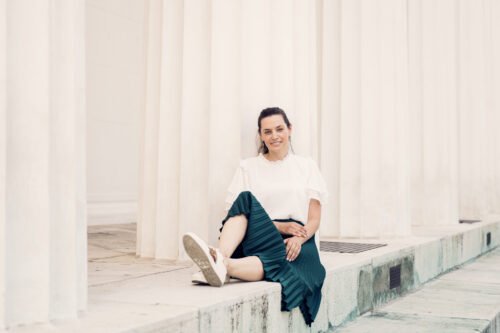 Adriana at Theseustemple Vienna with neoclassical Greek columns and white marble architecture backdrop.