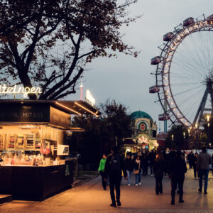 Iconic Bitzinger Würstelstand Prater with Vienna's historic Riesenrad illuminated in the background, creating a magical evening scene.