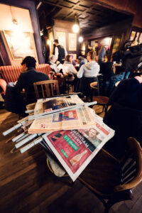 Traditional newspaper holders at Café Hawelka, filled with daily papers.