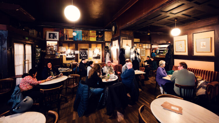 Time-worn interior of Café Hawelka, where smoke-darkened walls and original furnishings preserve authentic coffee house atmosphere.