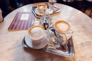 Morning ritual at Café Hawelka: perfectly crafted Melange on marble-topped table.