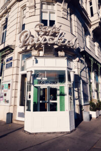 Inviting entrance of Café Prückel, framed by original 1950s signage and modernist details.